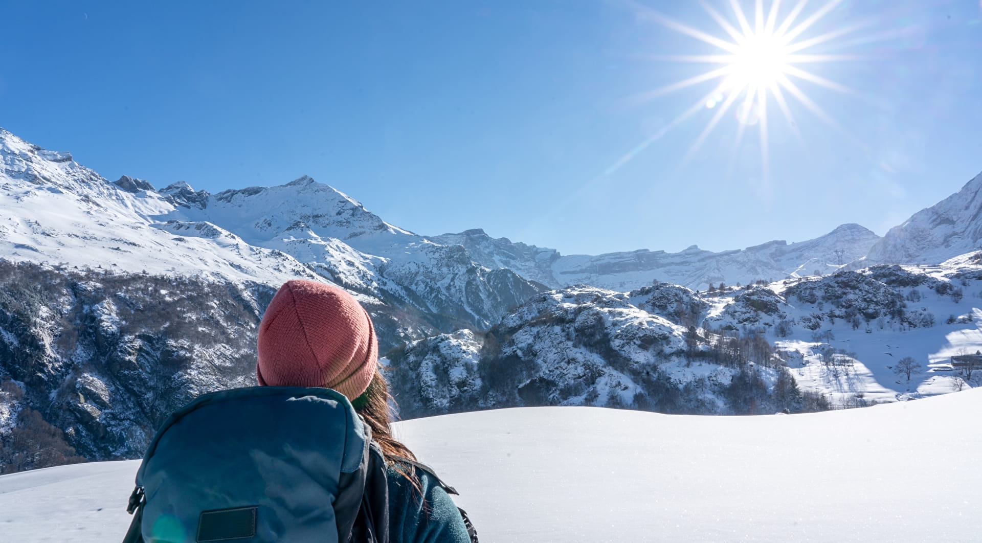 Femme qui marche en raquettes face aux montagnes